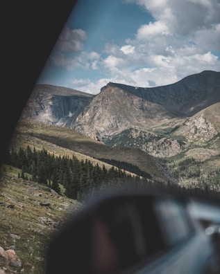 A scenic outdoor view of mountains with a clear blue sky, perfect for adventure