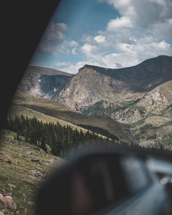 Snapshot of a travel vlog with a scenic mountain landscape under a clear blue sky.