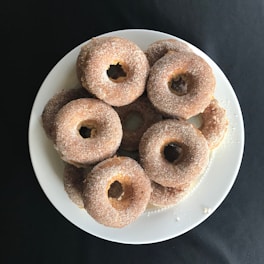 Close-up of a beautifully arranged plate with mini donuts and hotcakes on a cream-colored table.