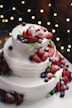 close-up photography of 3-tier vanilla cake with blueberry and strawberry toppings