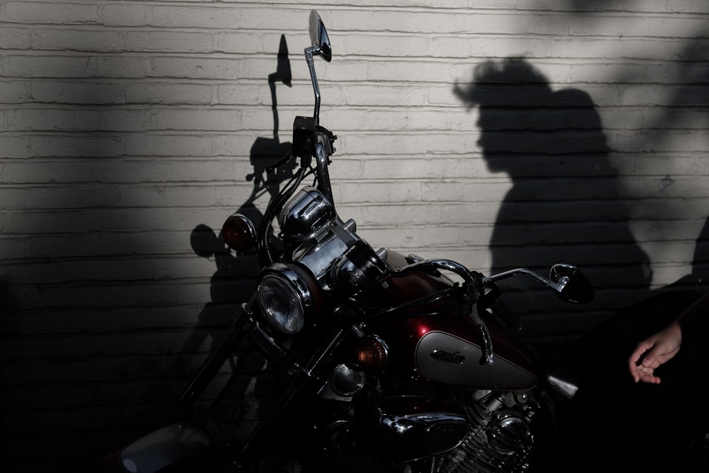 black motorcycle parked beside gray wall