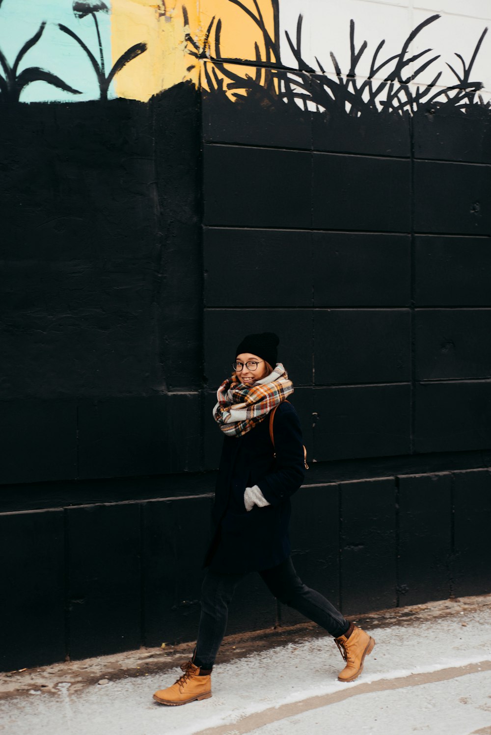 woman waking beside black painted wall