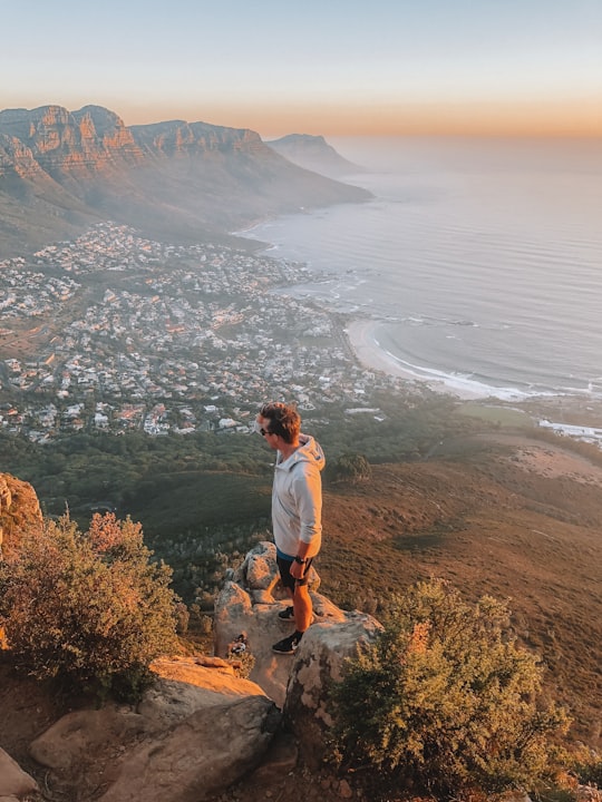 man standing on ledge overlooking town in Table Mountain National Park South Africa