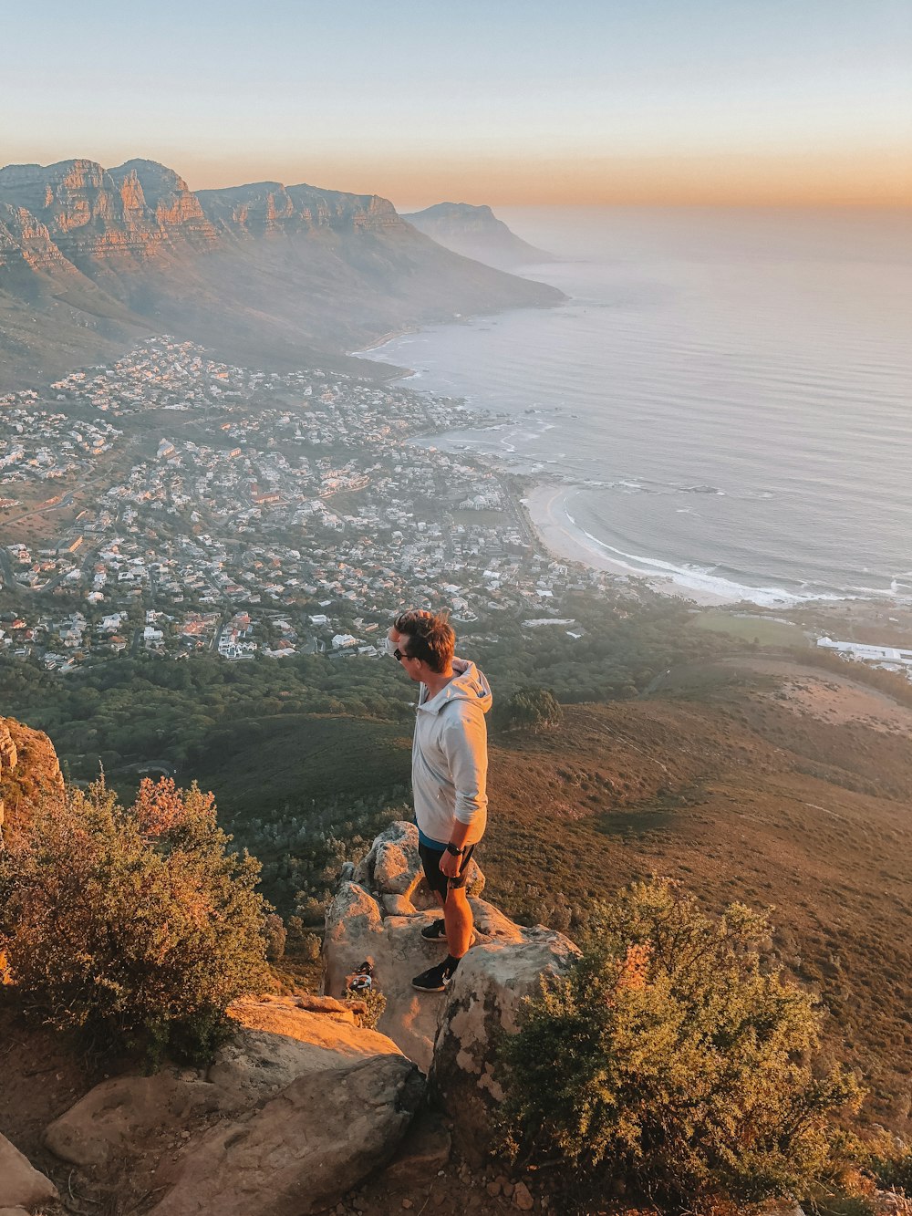 man standing on ledge overlooking town