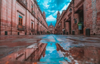 empty alley with buildings on side under blue sky