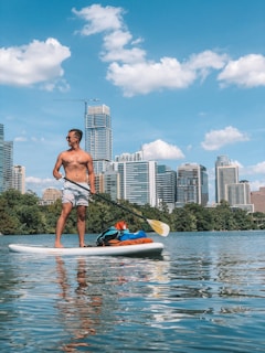 man in white shorts on paddle board