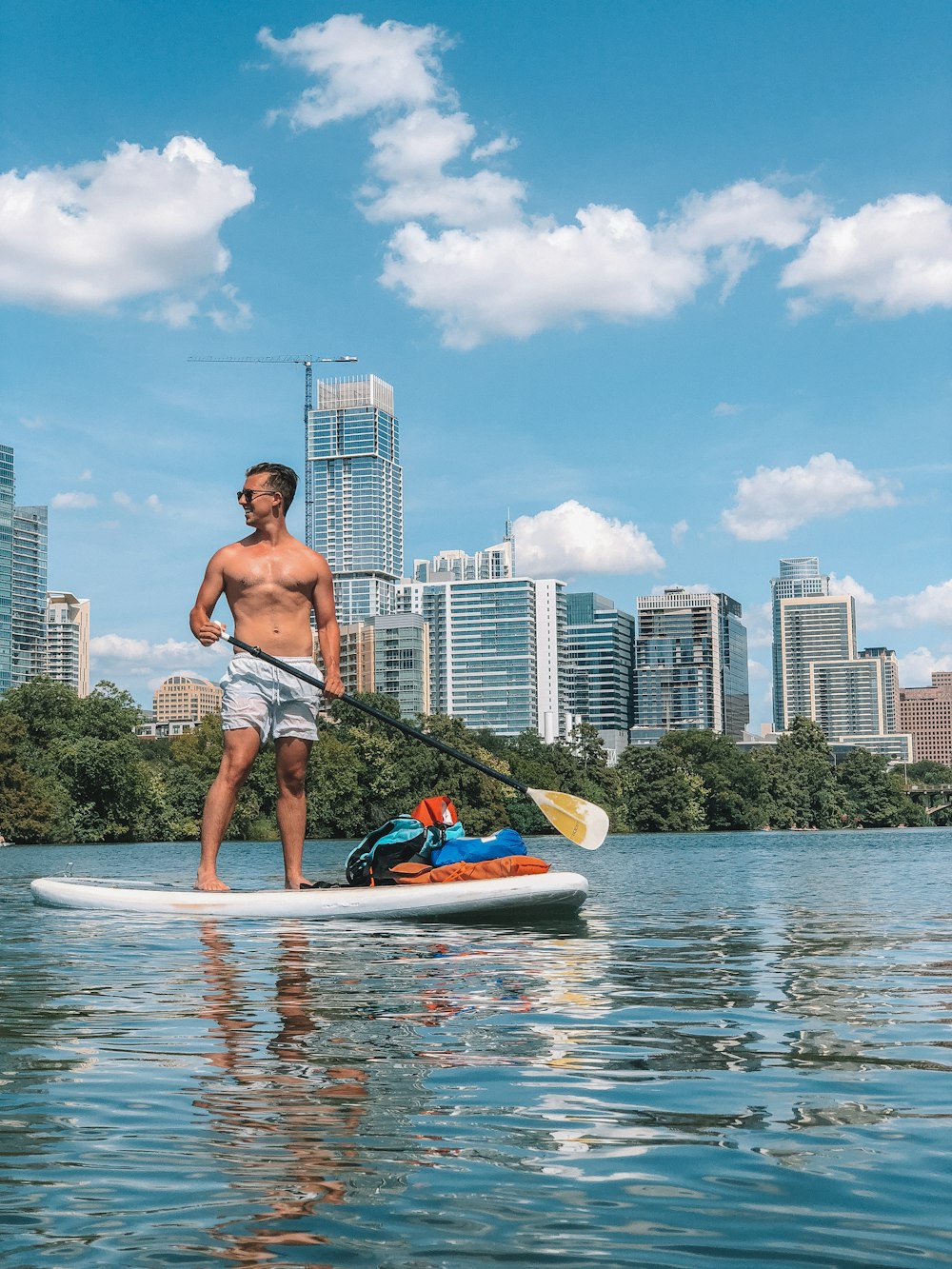 man in white shorts on paddle board