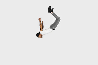 Jerry T. Adams executing a dynamic stunt on a film set, captured in sharp detail against a minimalist background.