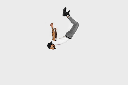 Jerry T. Adams executing a dynamic stunt on a film set, captured in sharp detail against a minimalist background.
