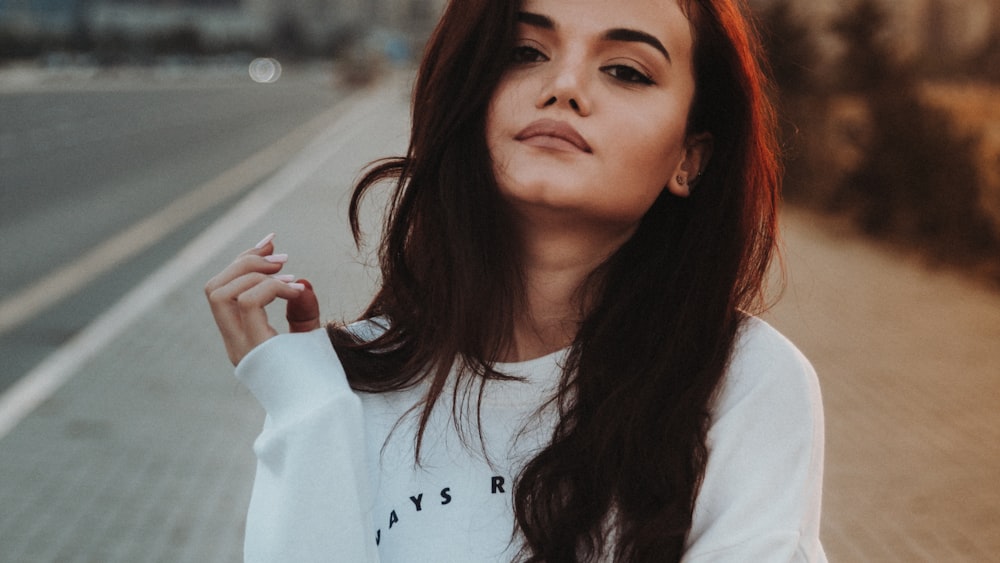 mujer en suéter blanco tomando selfie