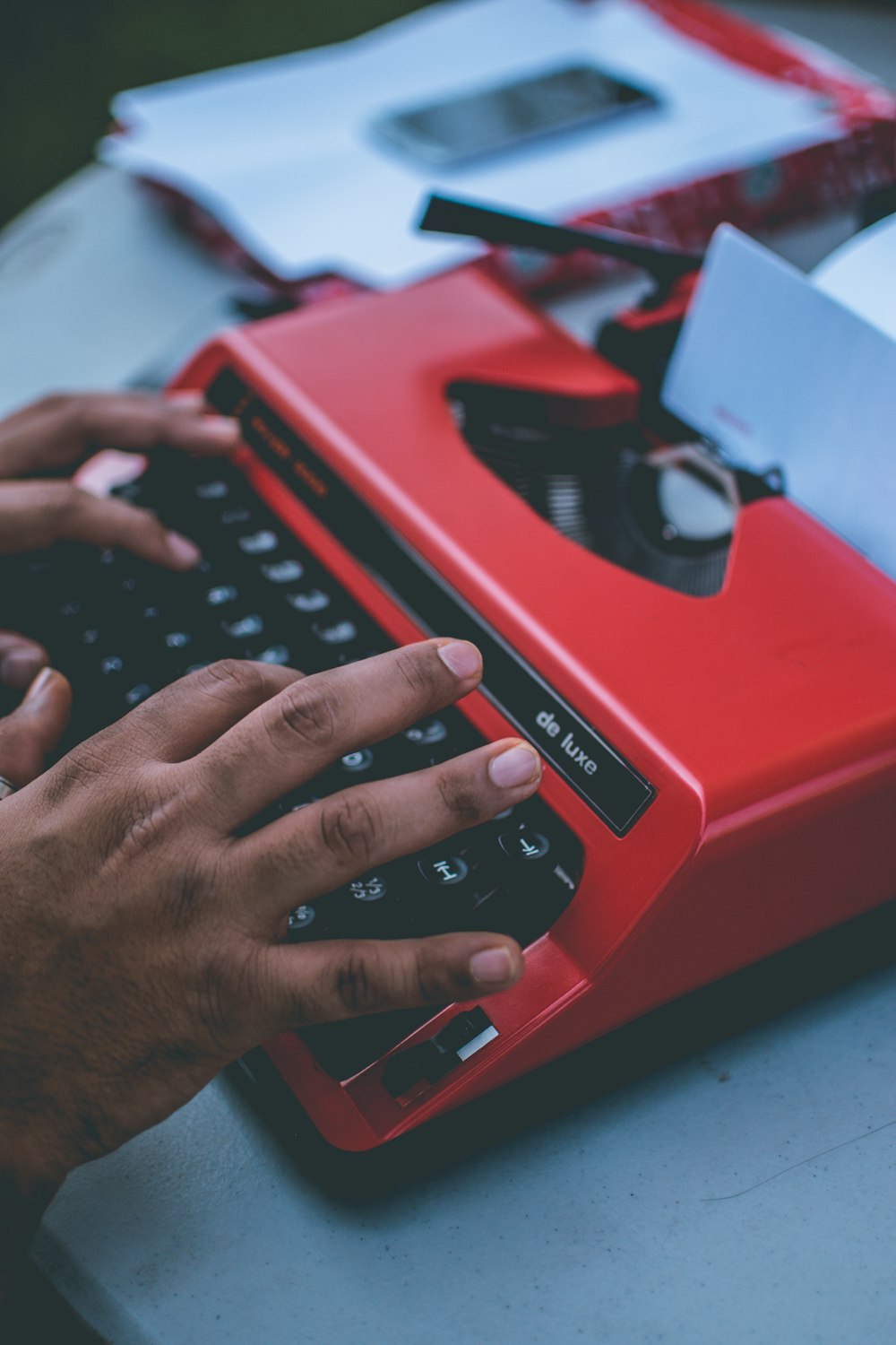 persona escribiendo en maquina de escribir roja