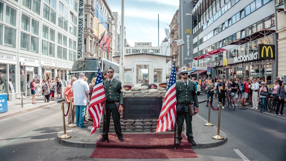 dos hombres sosteniendo banderas de Estados Unidos al aire libre