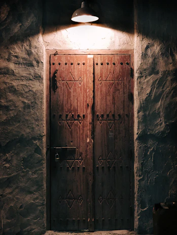 A rustic wooden door with intricate carvings, bathed in warm natural light.