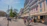 A lively street scene in Bucharest with colorful buildings and people enjoying a sunny day.