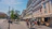 A lively street scene in Bucharest with colorful buildings and people enjoying a sunny day.