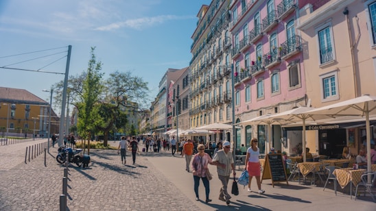 A cozy European street scene with colorful buildings and people enjoying a sunny day.