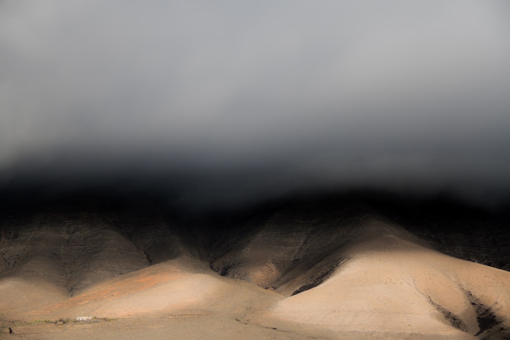 a group of hills under a cloudy sky