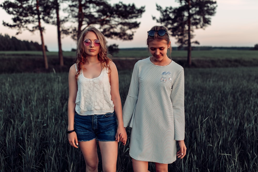 two woman walking on grass land