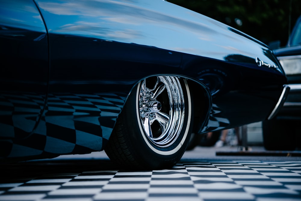 blaues Auto auf schwarz-weiß kariertem Boden geparkt