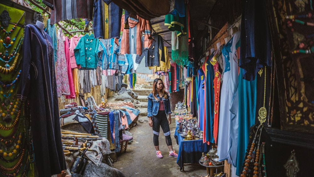 woman surrounded by assorted color apparel