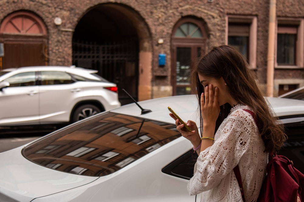 woman wearing white blouse beside white vehicle