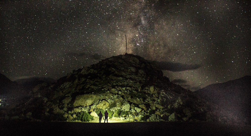 two person standing near mountain