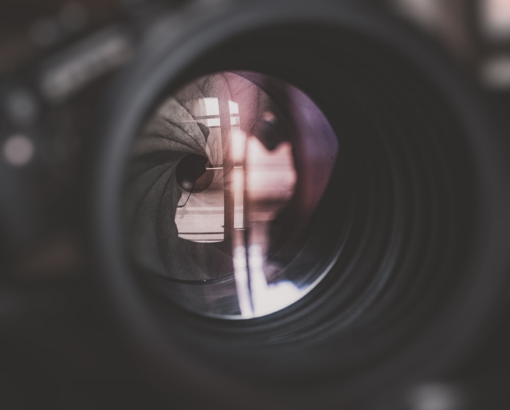 a close up of a camera lens with a person's reflection in it