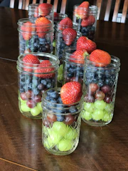 A variety of frozen individual meal jars neatly arranged on a rustic wooden table.