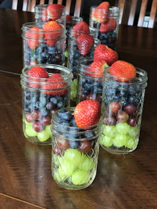 A variety of frozen individual meal jars neatly arranged on a rustic wooden table.