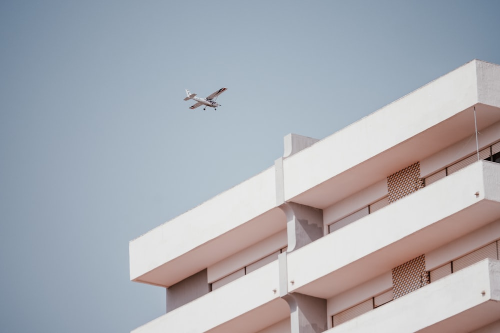 white monoplane passing thru building