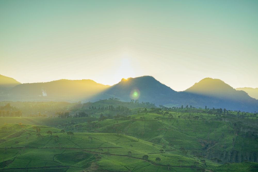 foto da paisagem do campo verde e das montanhas durante o dia