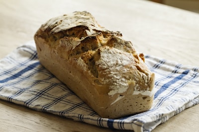 A warm loaf of artisan bread with a crispy crust resting on a linen cloth.