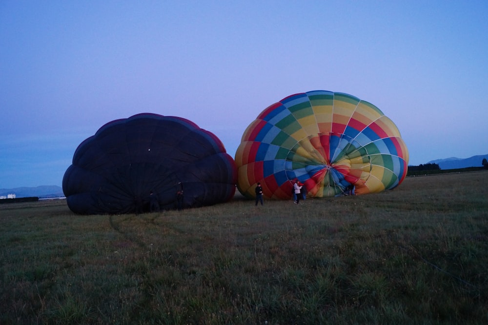 two hot air balloons on grass field