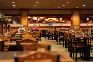 A warm, inviting dining area with wooden tables and a plate of loaded baked potatoes steaming on the table.