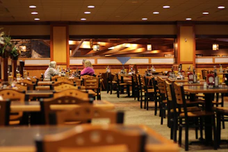 A warm, inviting dining area with wooden tables and soft lighting, bustling with happy guests enjoying their meals.