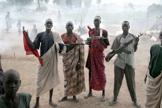 four men holding assault rifles