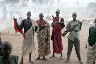 four men holding assault rifles