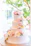 A beautifully decorated three-tier wedding cake with delicate floral accents in soft pastel colors.