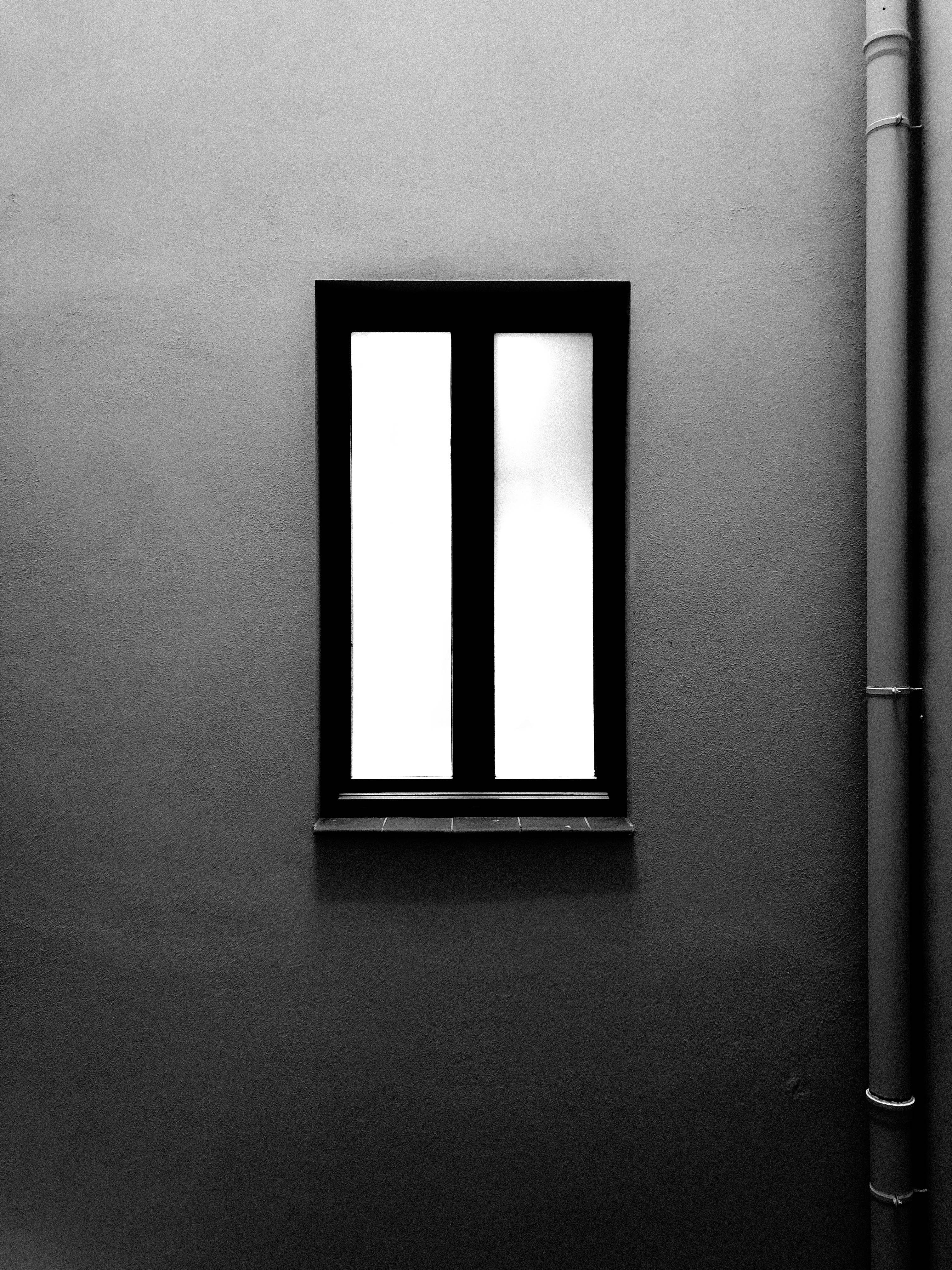 closed black framed window near wall