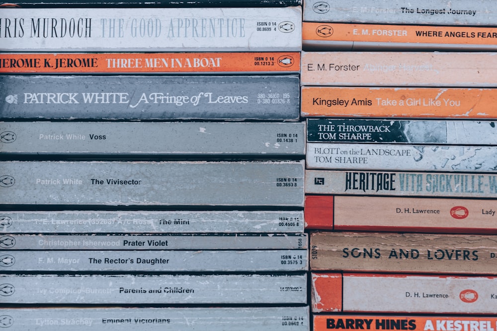 stack of books on brown wooden table