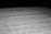 A close-up of a printed document with text in French, partially blurred, with the focus on specific lines of the text. The contrast between the dark background and the white paper emphasizes the content.