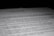 A close-up of a printed document with text in French, partially blurred, with the focus on specific lines of the text. The contrast between the dark background and the white paper emphasizes the content.