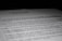 A close-up of a printed document with text in French, partially blurred, with the focus on specific lines of the text. The contrast between the dark background and the white paper emphasizes the content.