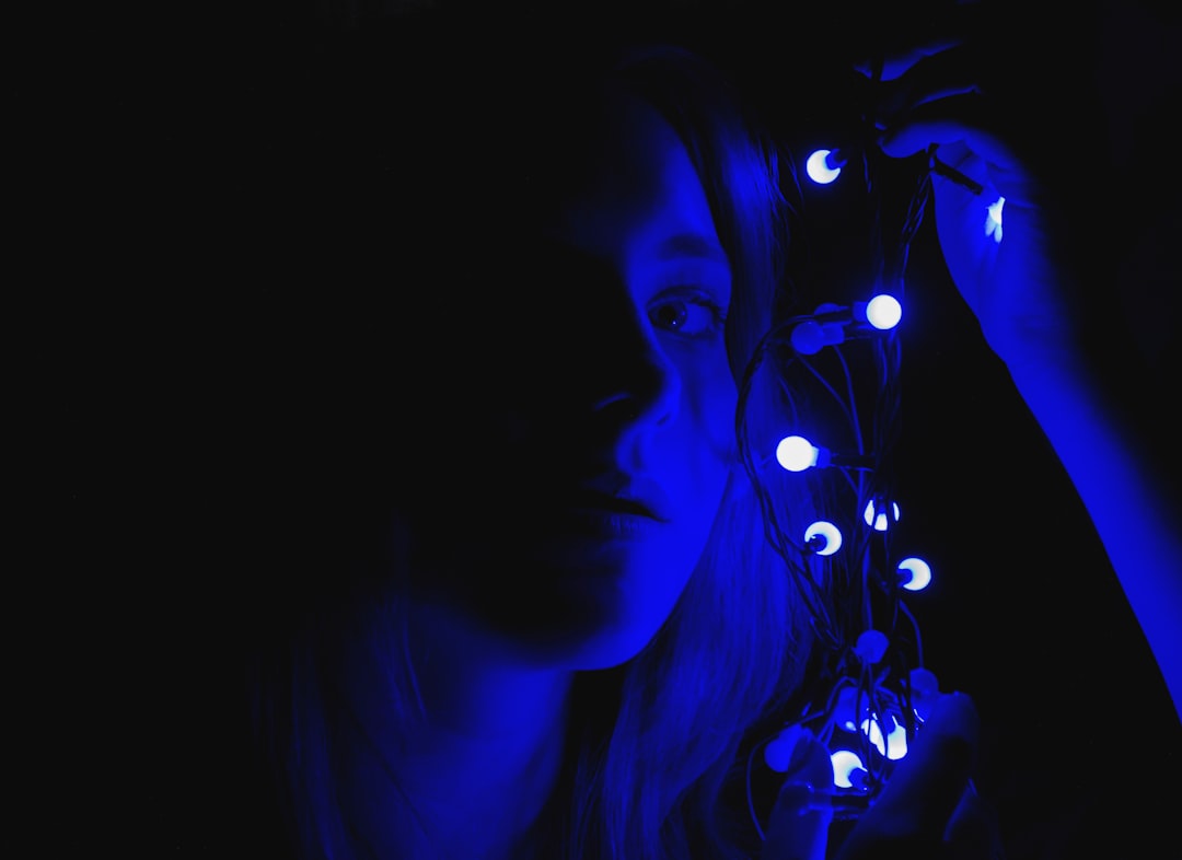 woman holding blue string lights