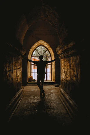 A shadowy figure of the corrupt officer standing in a dimly lit prison corridor, red light casting ominous shadows.