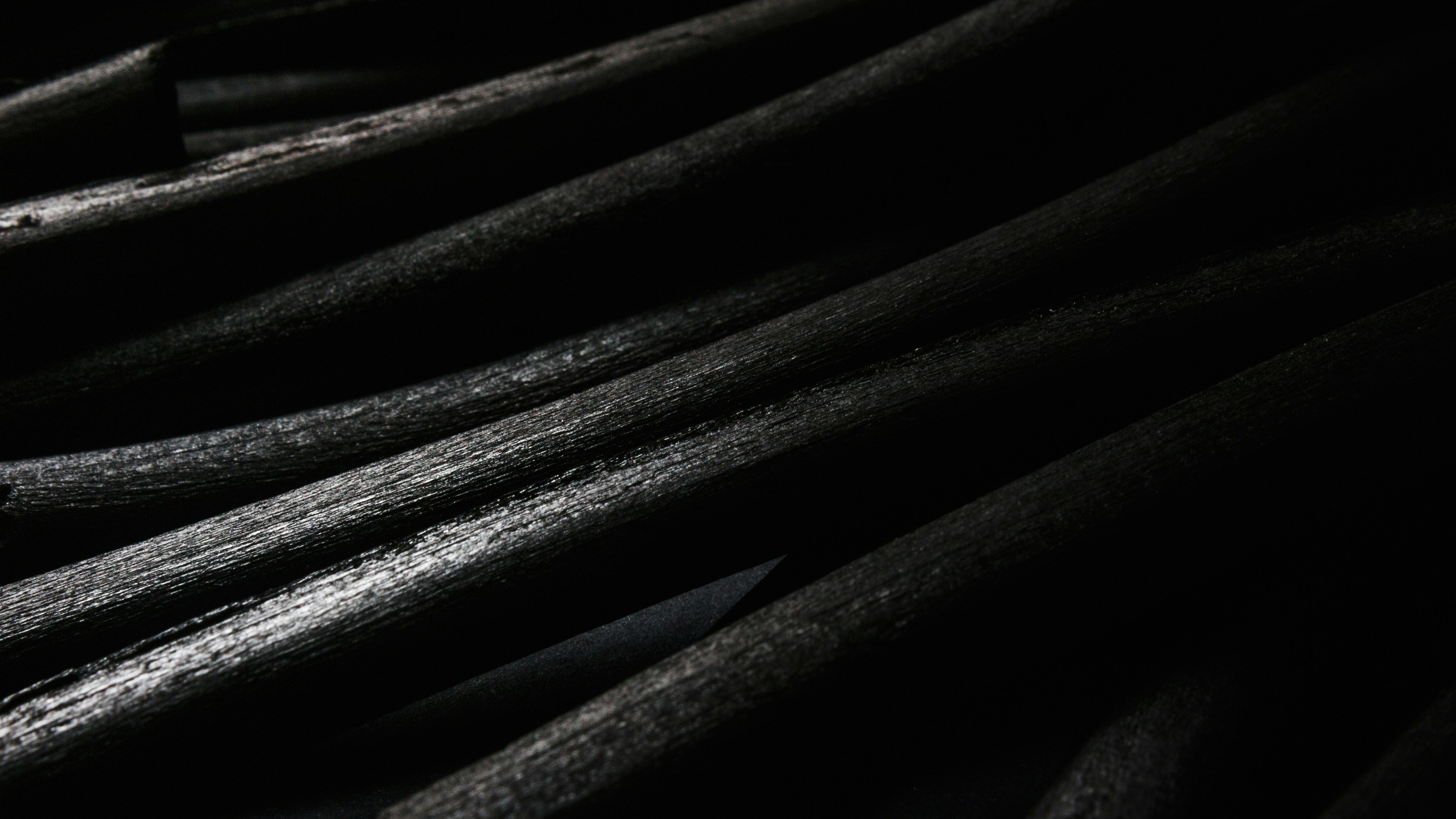 Close up of black folds or cables with a rough surface like rock or charcoal