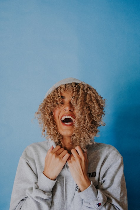 smiling woman wearing gray hoodie