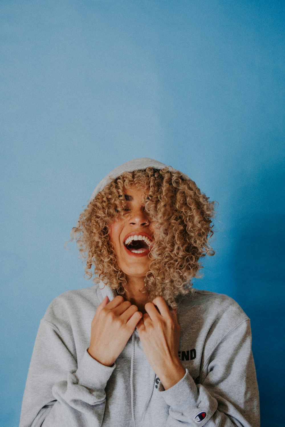 smiling woman wearing gray hoodie