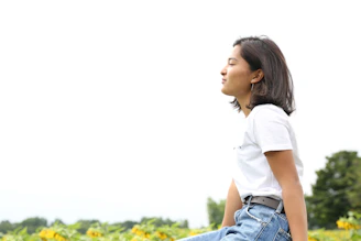 A relaxed person sitting in nature, eyes closed, embracing mindfulness.
