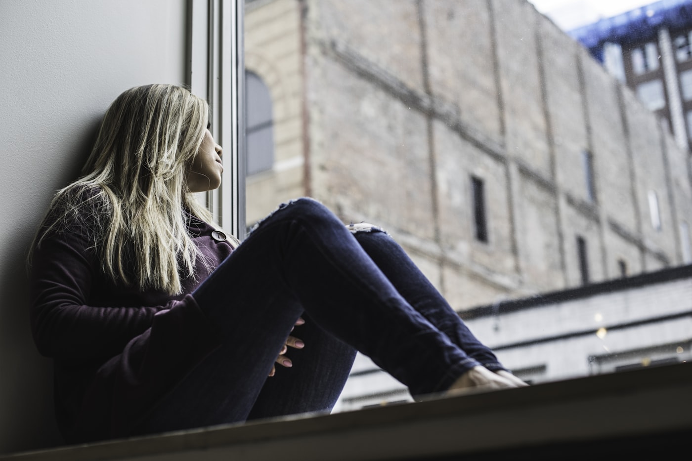 Woman sitting quietly by a window in soft evening light